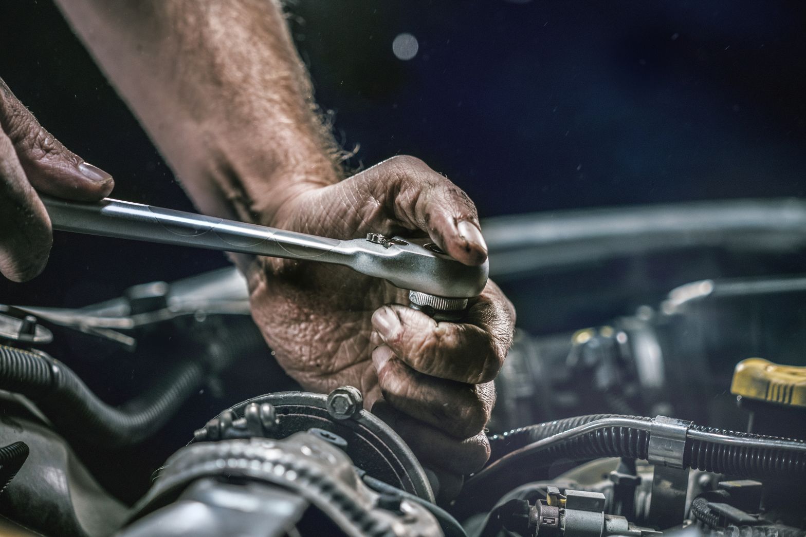 Auto mechanic working on car engine in mechanics garage. Repair service. authentic close-up shot